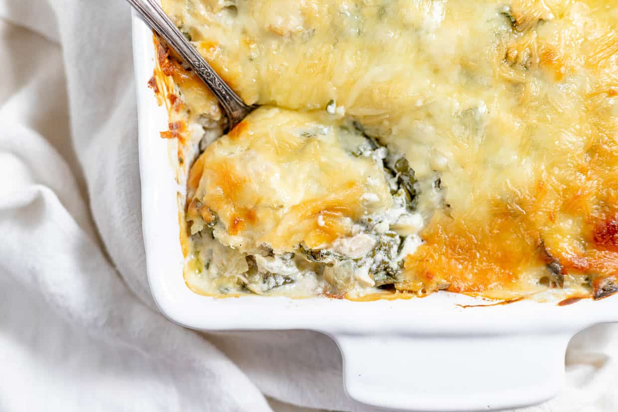 A spoon in a cheesy casserole.