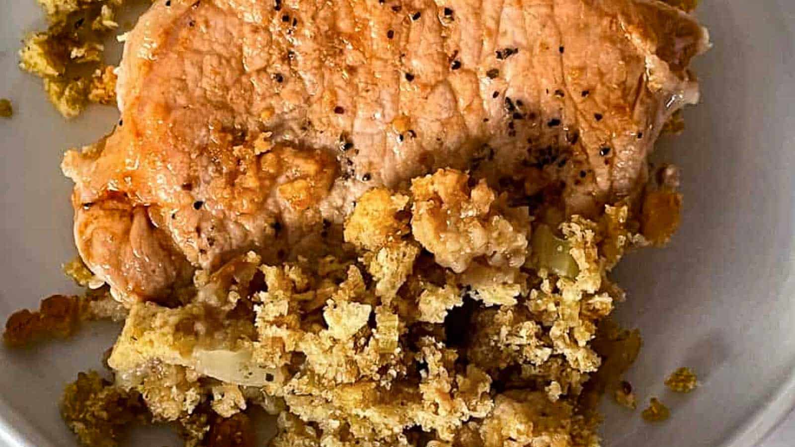 Stuffing and pork chops in a frying pan.